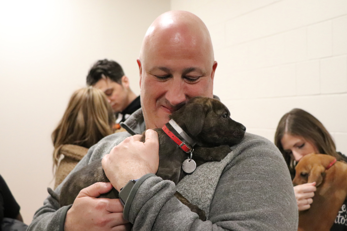 Tito's Volunteer holding puppy